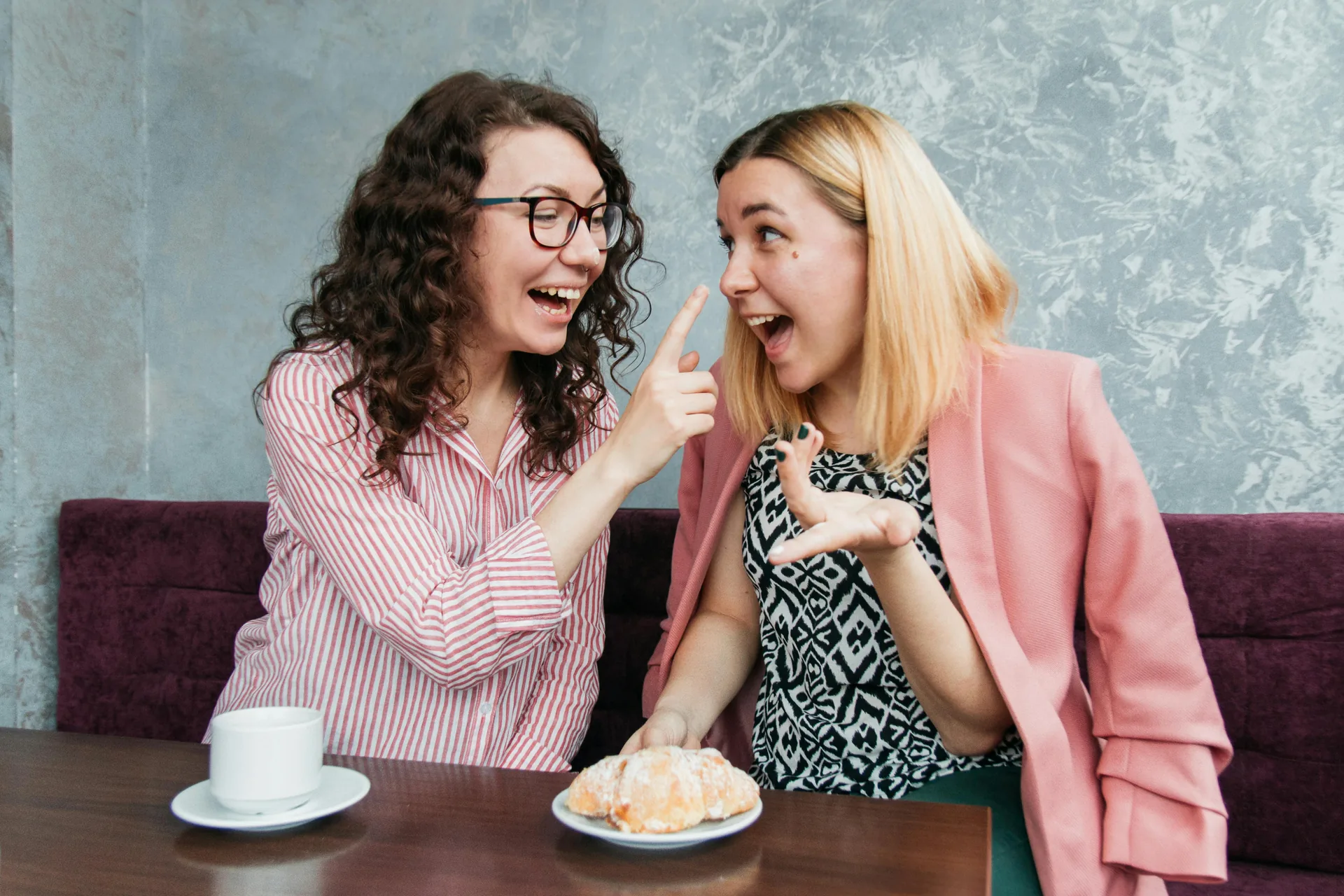 Two people laughing over coffee in a café